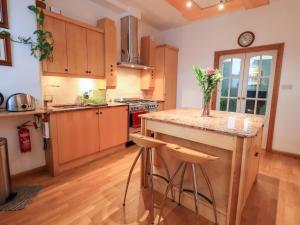 a kitchen with wooden cabinets and a counter with stools at The Bowery in Ambleside