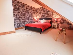 a bedroom with a bed with a red comforter at The Bowery in Ambleside