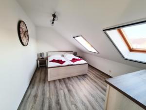 1 dormitorio con 2 camas y reloj en la pared en DM Hotes & Apartments - Apartment Dosborn 5-9, en Dingelstädt