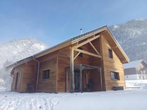 ein Blockhaus im Schnee mit Bergen im Hintergrund in der Unterkunft Chalet La Morte in La Morte
