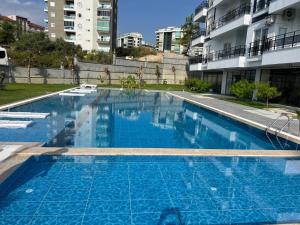 a large blue swimming pool in front of a building at Art life aparments (watermelone) in Alanya