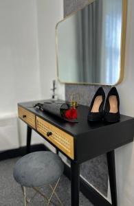 a black desk with a mirror and a pair of shoes at Kos apartament 1 in Walton on the Hill