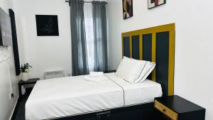a bedroom with a white bed with a yellow headboard at Kos apartament 1 in Walton on the Hill