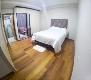 a bedroom with a bed and a wooden floor at Apartamento Luz de Luna2 in La Paz