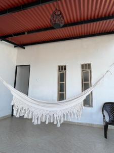 a white curtain hanging in a room with a chair at San Jorge VVC in Villavicencio