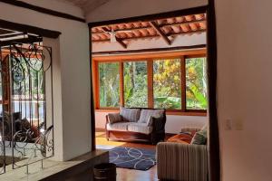 a living room with a couch and a mirror at Refugio e Conforto: Mata/Hidro/Área Gourmet/Wifi in São Sebastião