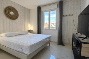une chambre avec un lit, une fenêtre et une télévision dans l'établissement 66 m all comfort in Saint-Raphaël, à Saint-Raphaël