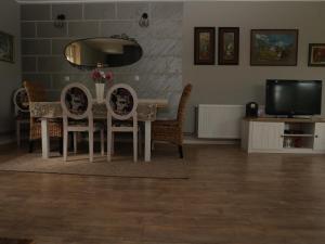 a dining room with a table and chairs and a television at Villa Mira in Mačkat