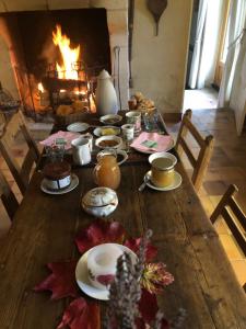 a wooden table with food on it with a fireplace at Domaine Moulin de Boiscorde 1h45 Paris in Rémalard en Perche