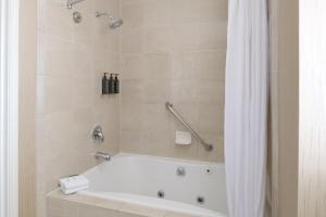 a bathroom with a bath tub with a shower curtain at Sheraton Sonoma Wine Country Petaluma in Petaluma