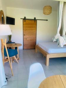 a bedroom with a bed and a table and a door at HAMACA 107 KAWANN CENTER in Grand-Bourg