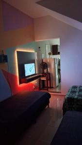 um quarto com uma cama e uma televisão num quarto em kitnet em São João Del Rei, a 11km de Tiradentes MG em São João del Rei