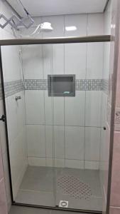um chuveiro com uma porta de vidro na casa de banho em kitnet em São João Del Rei, a 11km de Tiradentes MG em São João del Rei