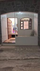 uma porta aberta para um quarto com um portão em kitnet em São João Del Rei, a 11km de Tiradentes MG em São João del Rei