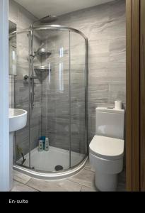 a bathroom with a shower and a toilet and a sink at White 3 bed bungalow with en-suite and parking in Winford