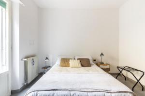 ローマにあるMonteverde lovely flatのベッドルーム(白い大型ベッド、ランプ2つ付)