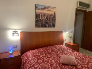 um quarto com uma cama com uma colcha vermelha em Holiday Home 40 em Santa Maria delle Mole