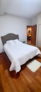 Elle comprend un grand lit blanc avec des draps et des oreillers blancs. dans l'établissement Apartamento Luz de Luna1, à La Paz