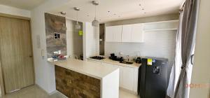 a kitchen with a counter and a refrigerator at Domus - Rio Guatapuri Panoramic in Valledupar