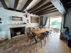 una sala da pranzo con tavolo e camino di Maison de Charme près de Sancerre: Jardin, Terrasse, Wifi, Activités Nautiques & Équestres - FR-1-586-40 a Saint-Bouize