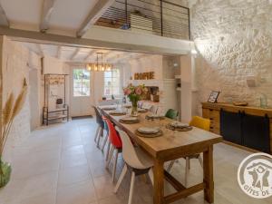 a large kitchen with a long table and chairs at Gîte troglodyte unique avec jacuzzi, billard et jardin, près de Doué La Fontaine et Saumur - FR-1-622-69 in Les Ulmes
