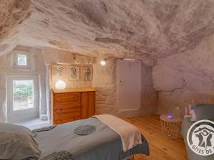 ein Schlafzimmer mit einem Bett und einer Steinmauer in der Unterkunft Gîte Les Ulmes, 3 pièces, 4 personnes - FR-1-622-69 in Les Ulmes