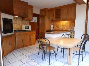 a kitchen with wooden cabinets and a wooden table and chairs at Gîte au calme avec 2 chambres, terrasse, jardin, BBQ et parking inclus à Breitenbach-Haut-Rhin - FR-1-744-42 in Breitenbach-Haut-Rhin