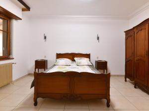 1 Schlafzimmer mit einem Holzbett und 2 Kommoden in der Unterkunft Gîte Oberentzen, 4 pièces, 6 personnes - FR-1-744-40 in Oberentzen