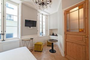 Schlafzimmer mit einem Bett, einem TV und einem Fenster in der Unterkunft Pavillon Marais in Paris