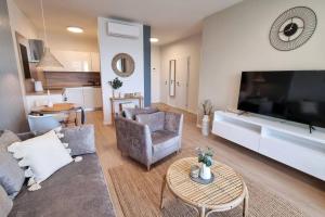 a living room with a couch and a large tv at 10 Minutes to City: Cozy Urban Apartment Stay in Bratislava