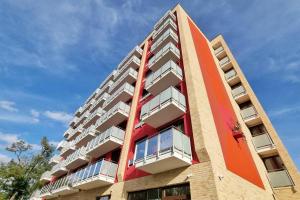 10 Minutes to City: Cozy Urban Apartment Stay في براتيسلافا: مبنى طويل وبه شرفات على جانبه