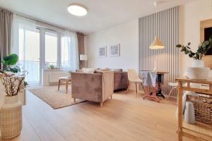 10 Minutes to City: Cozy Urban Apartment Stay في براتيسلافا: غرفة معيشة مع أريكة وطاولة