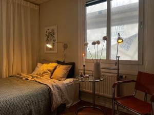 1 dormitorio con cama, ventana y silla en Ewa & Maude Hotel Aston Villa en Gotemburgo