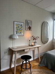 a desk in a bedroom with a lamp and a candle at Ewa & Maude Hotel Aston Villa in Gothenburg