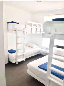 a room with three bunk beds and a ladder at Departamento Paracas vista al mar in Paracas