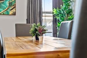 a wooden table with two plants on top of it at Spacious Fully Furnished Apartment by Logan Airport in Boston