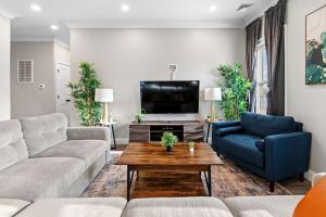 a living room with a couch and a tv at Spacious Fully Furnished Apartment by Logan Airport in Boston