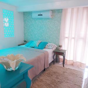 a bedroom with a bed with blue and pink at Hospede Mar Bombinhas in Bombinhas