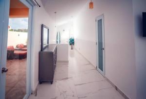 a hallway with white walls and a room with a couch at Paradise Coast Penthouse - Luxury in Paradise in Isabela