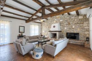 a living room with couches and a stone fireplace at Villa Leopoldo by Istrian Country Houses in Barat