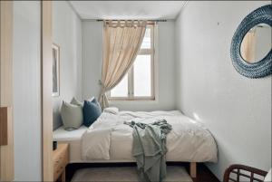 Schlafzimmer mit einem Bett und einem Fenster in der Unterkunft Bergen city center apartment in Bergen