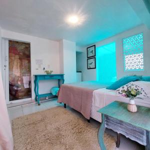 Dormitorio azul con cama y mesa en Hospede Mar Bombinhas, en Bombinhas