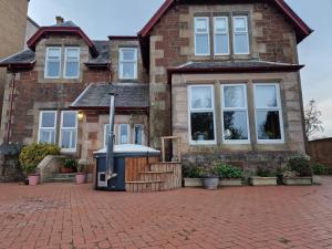 a brick house with a fountain in front of it at The Old Rectory in Largs