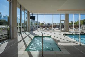 einen Pool in einem Gebäude mit Glasfenstern in der Unterkunft Delta Hotels by Marriott Wichita Falls Convention Center in Wichita Falls