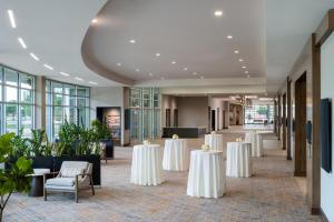 ウィチタフォールズにあるDelta Hotels by Marriott Wichita Falls Convention Centerの白いテーブルと椅子が備わる宴会場