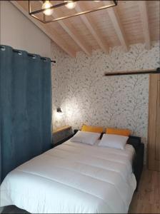 a bedroom with a bed with white sheets and orange pillows at Los Sauces de la Fuente in Santillana del Mar