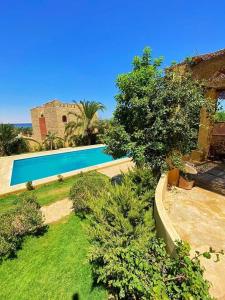 een zwembad in een tuin met bomen en planten bij Khan tunis villa in Tunis