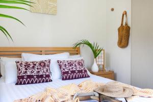 a bed with pillows and a hat on it at Lily Pad at Byron Bay in Byron Bay