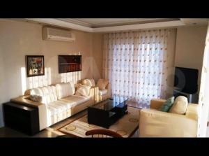 a living room with a white couch and a tv at Sokak in Alanya