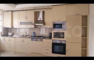 a kitchen with white cabinets and a stove top oven at Sokak in Alanya